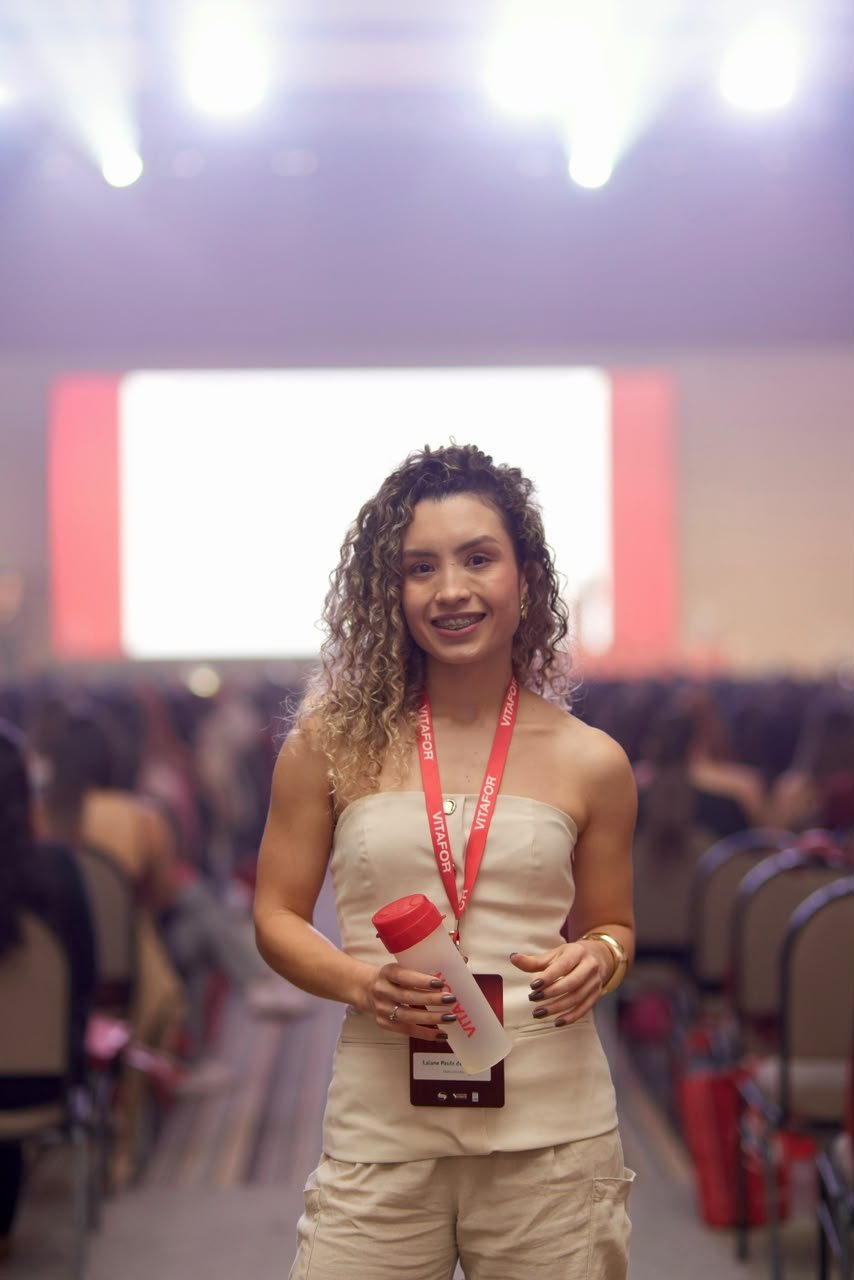 Laiane Oliveira com crachá em um evento profissional